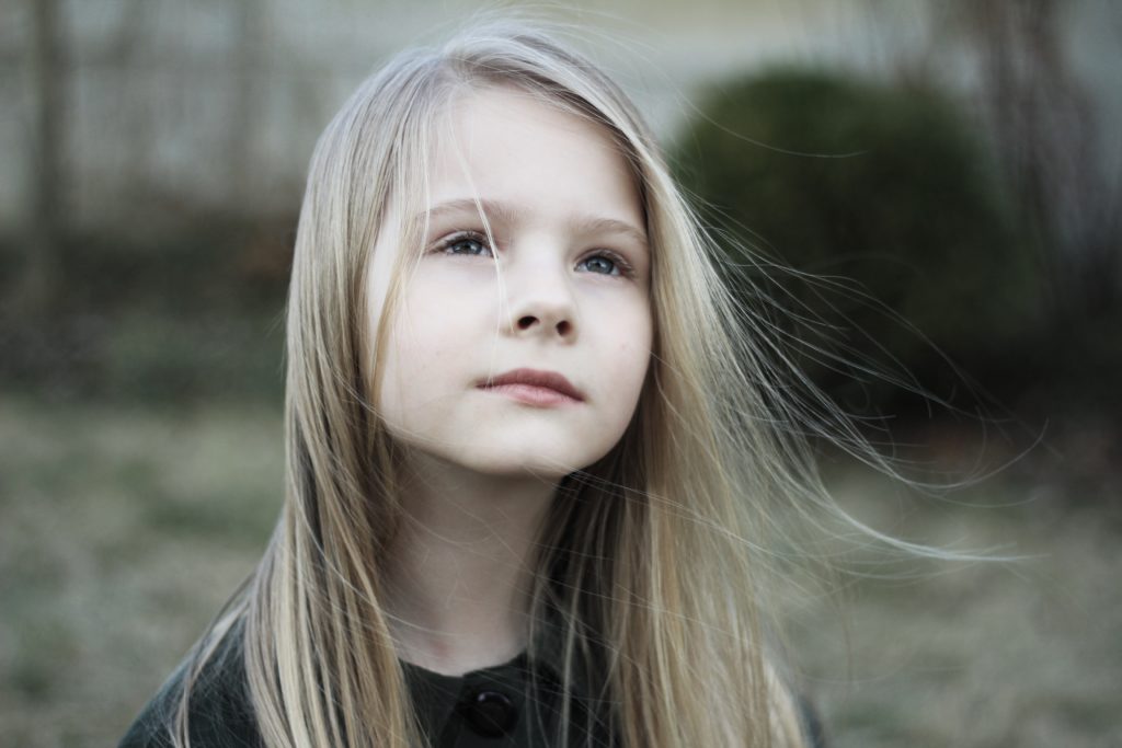 Young girl standing outside and thinking