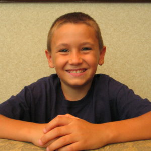 A boy smile at the table