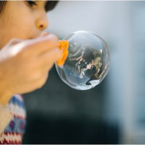 child blowing bubble