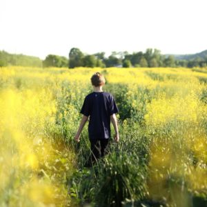 Boy walking through grass