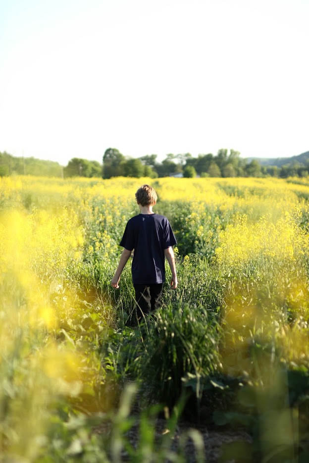 Boy walking through grass