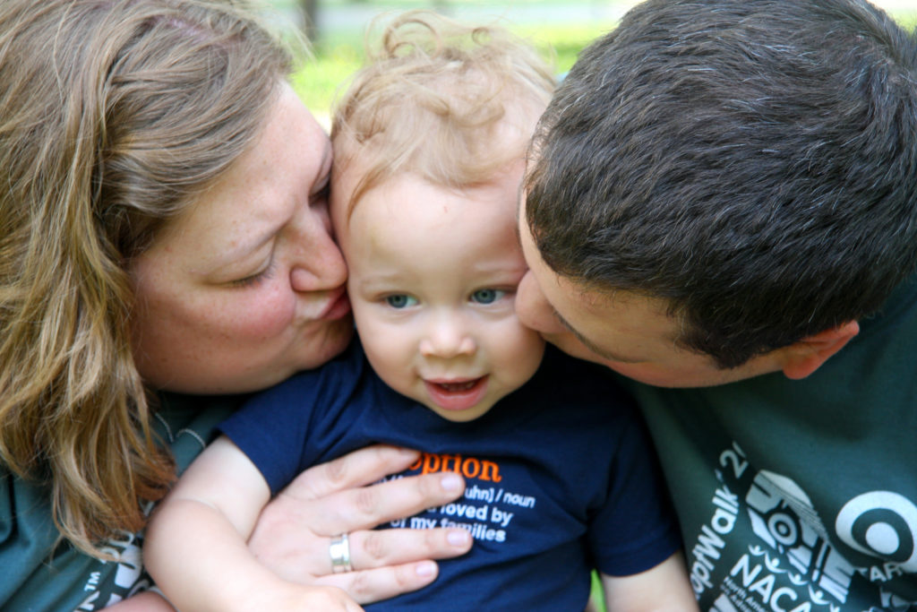parents-kissing-little-boy