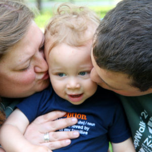 Parents kissing a little boy
