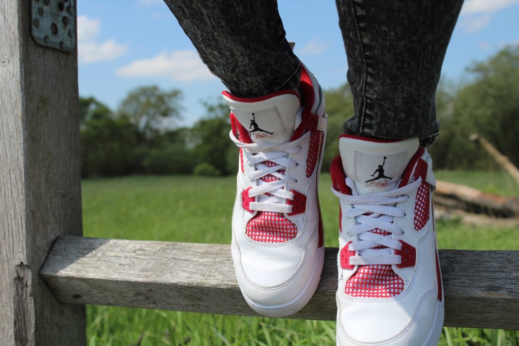 White and red sneakers on wooden fence