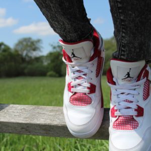 White and red sneakers on wooden fence